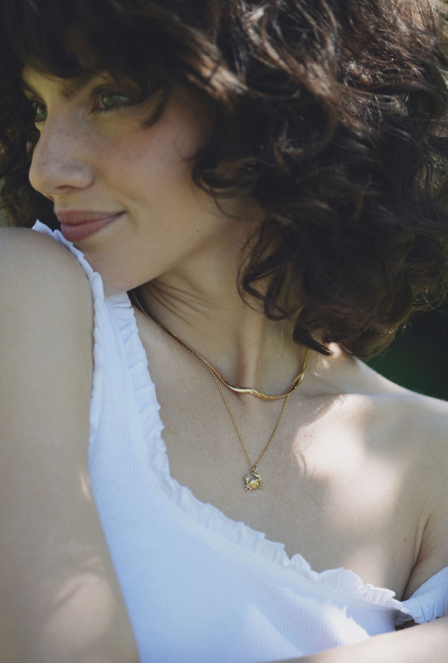 woman wearing yellow gold crab necklace