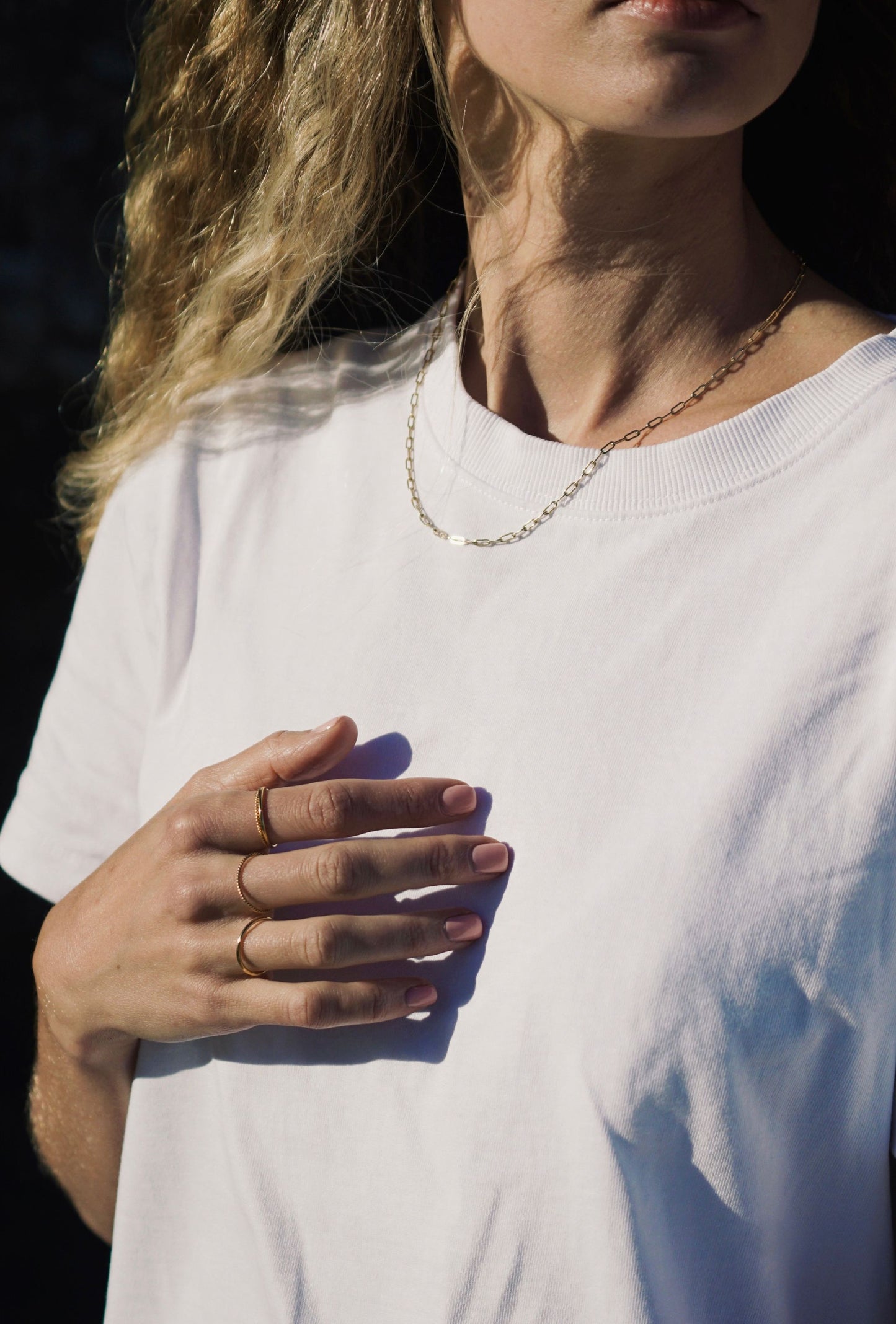 Women waering yellow gold paperclip chain by Thor Collective