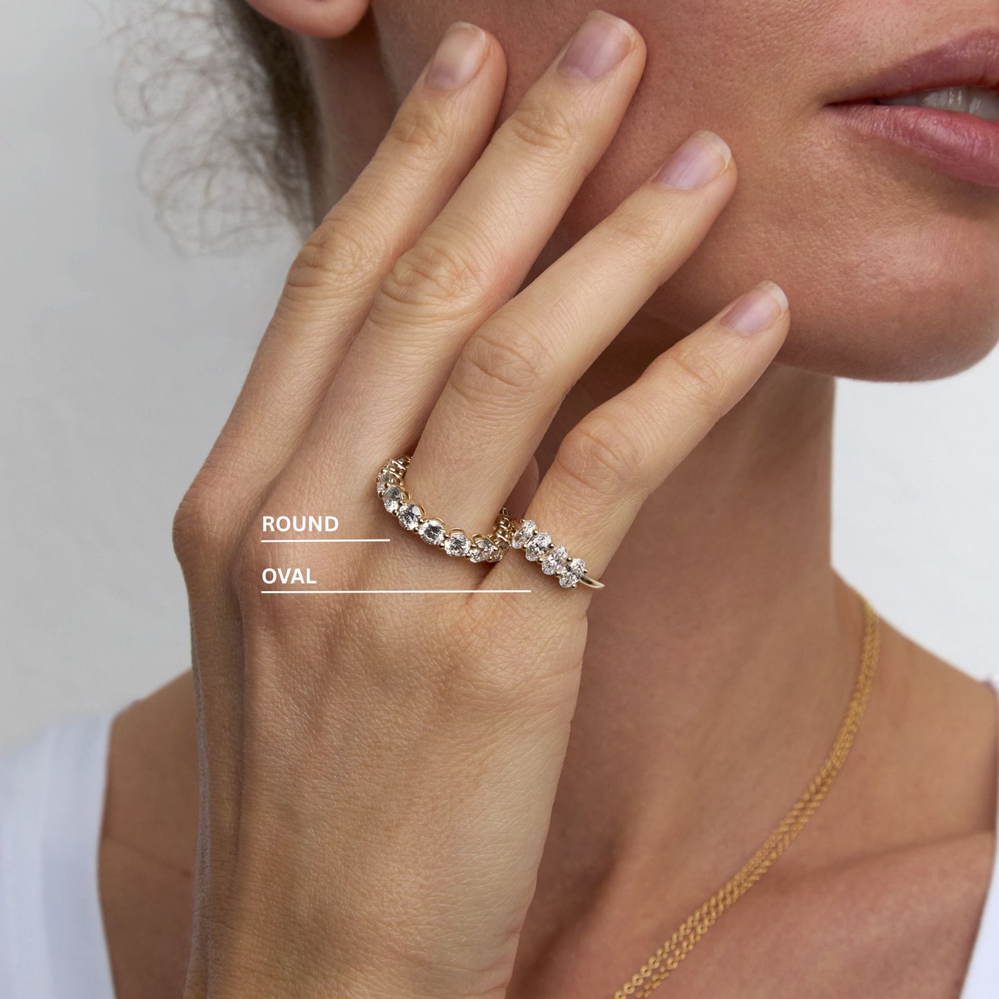 Round and oval lab grown diamond eternity rings stacked on hand in 9ct gold
