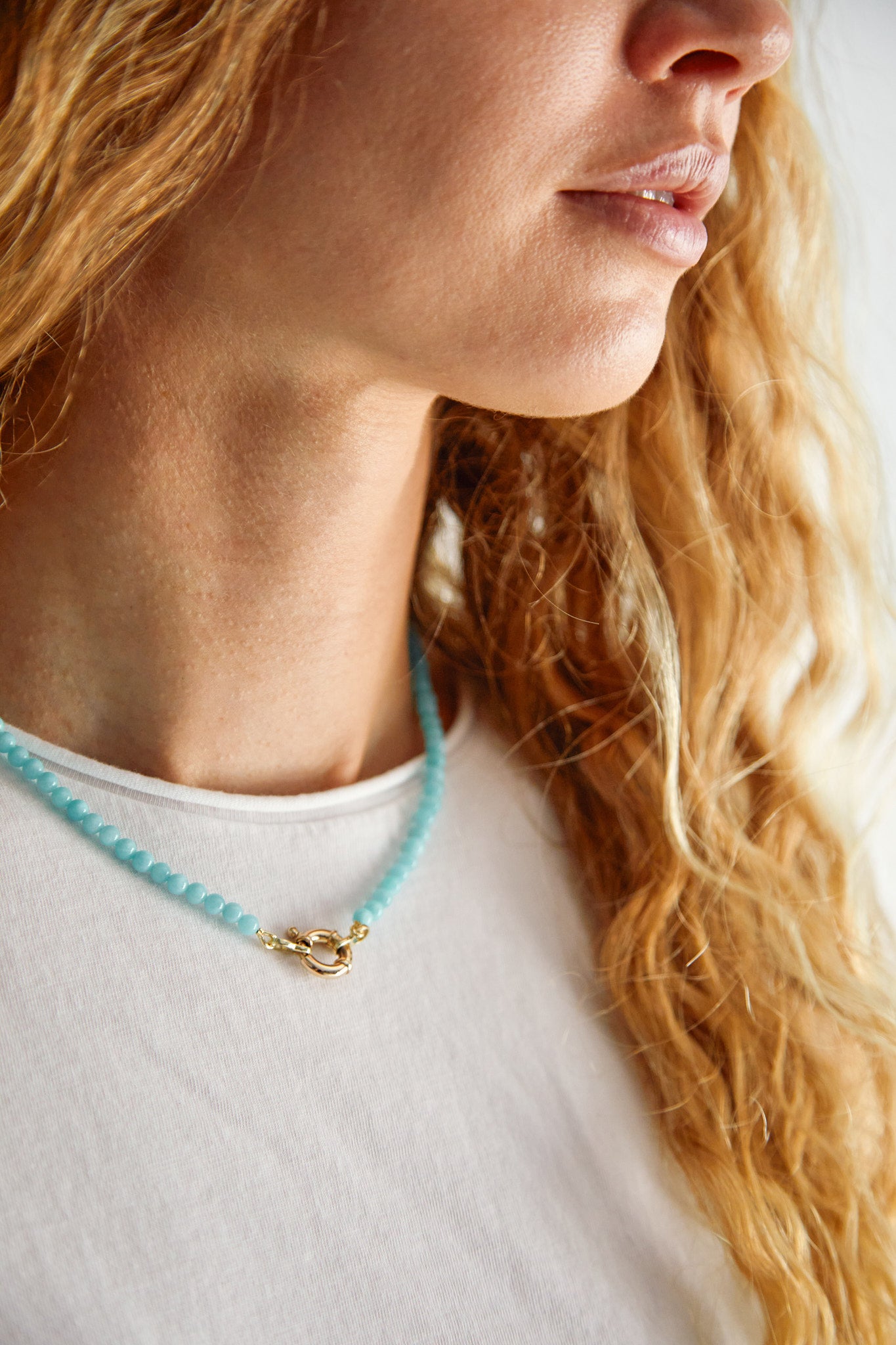 Model wearing 9ct gold amazonite gemstone necklace — fresh turquoise tones for effortless summer elegance.