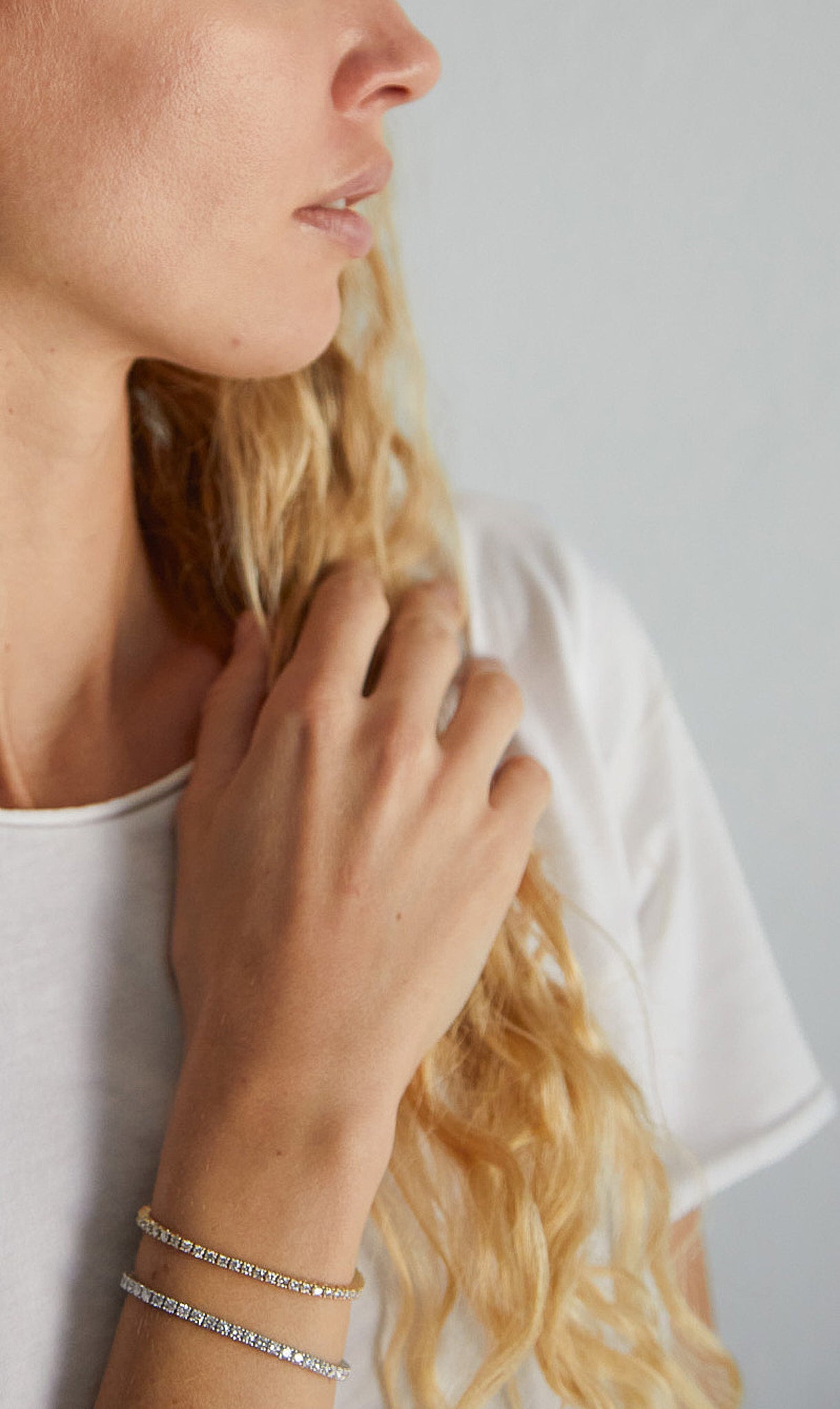 Side view of woman wearing two 9ct gold lab-grown diamond tennis bracelets