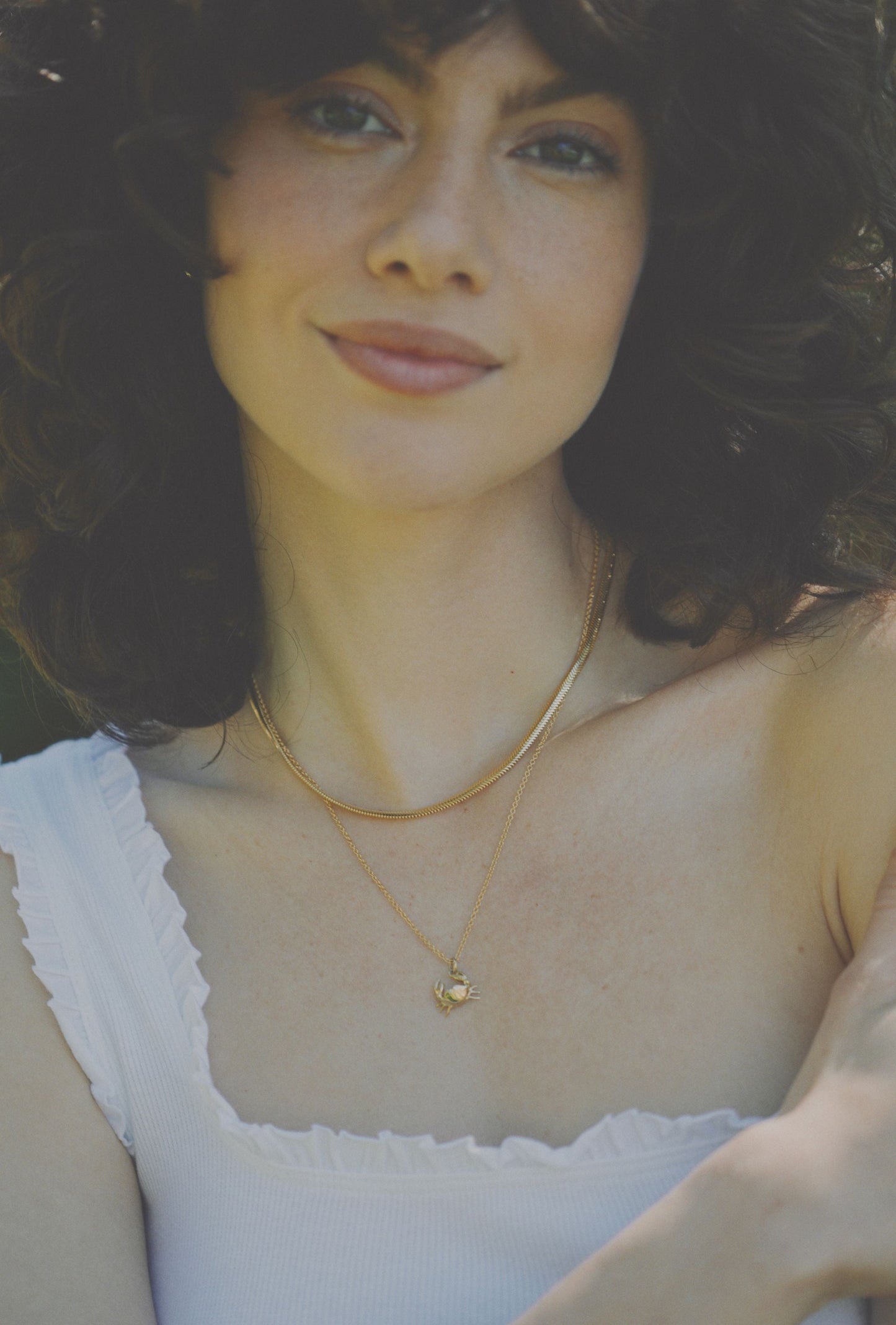 wearing gold crab necklace