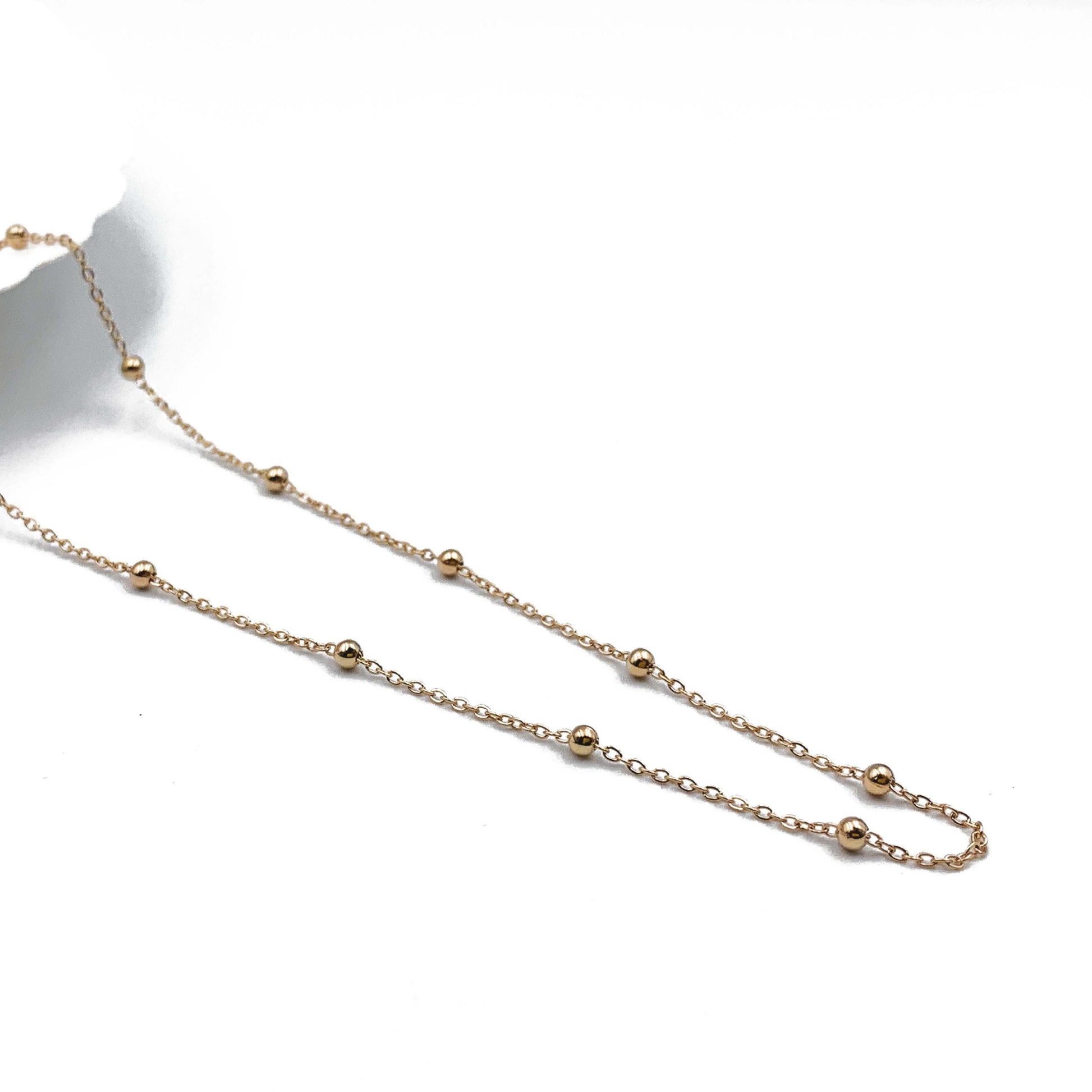 9ct yellow gold rolo bead necklace laid flat showing evenly spaced polished beads