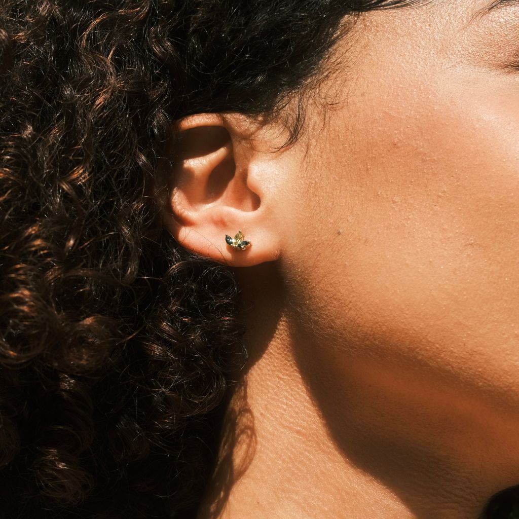 Model wearing 9ct yellow gold marquise green tourmaline and peridot stud earrings shown on ear