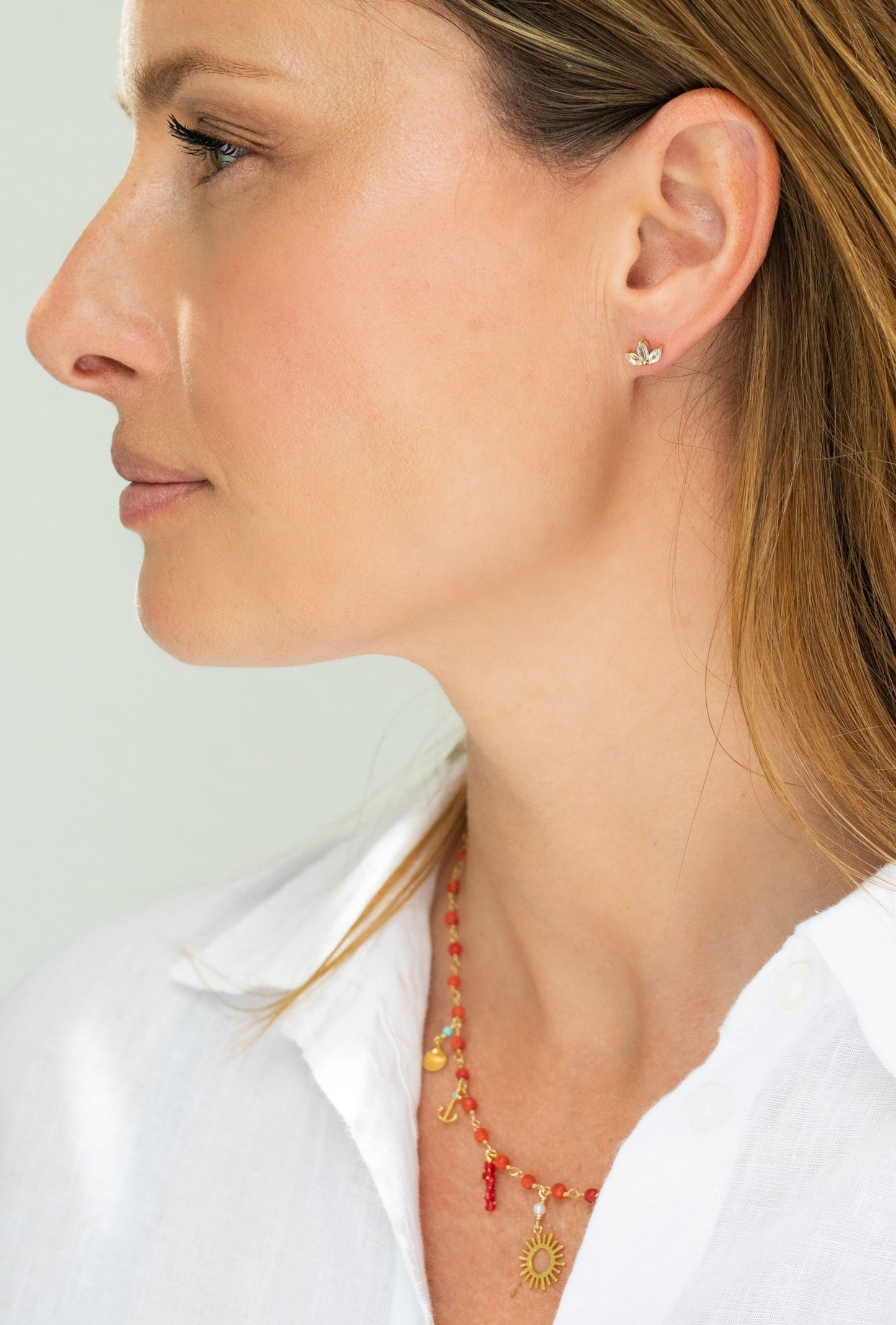 Side profile of model wearing 9ct gold marquise trio stud earrings in green tourmaline and peridot
