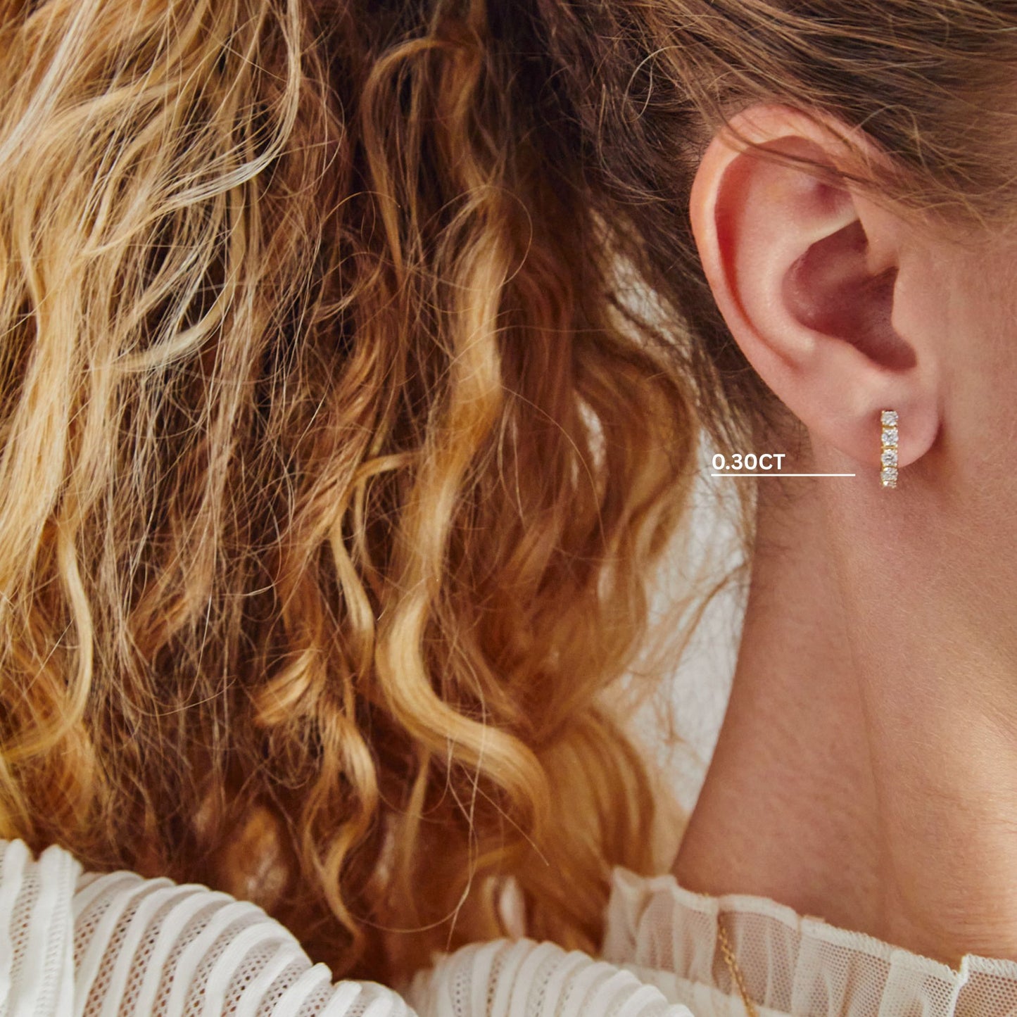 Close-up of 0.30ct lab grown diamond huggie earrings in 9ct yellow gold