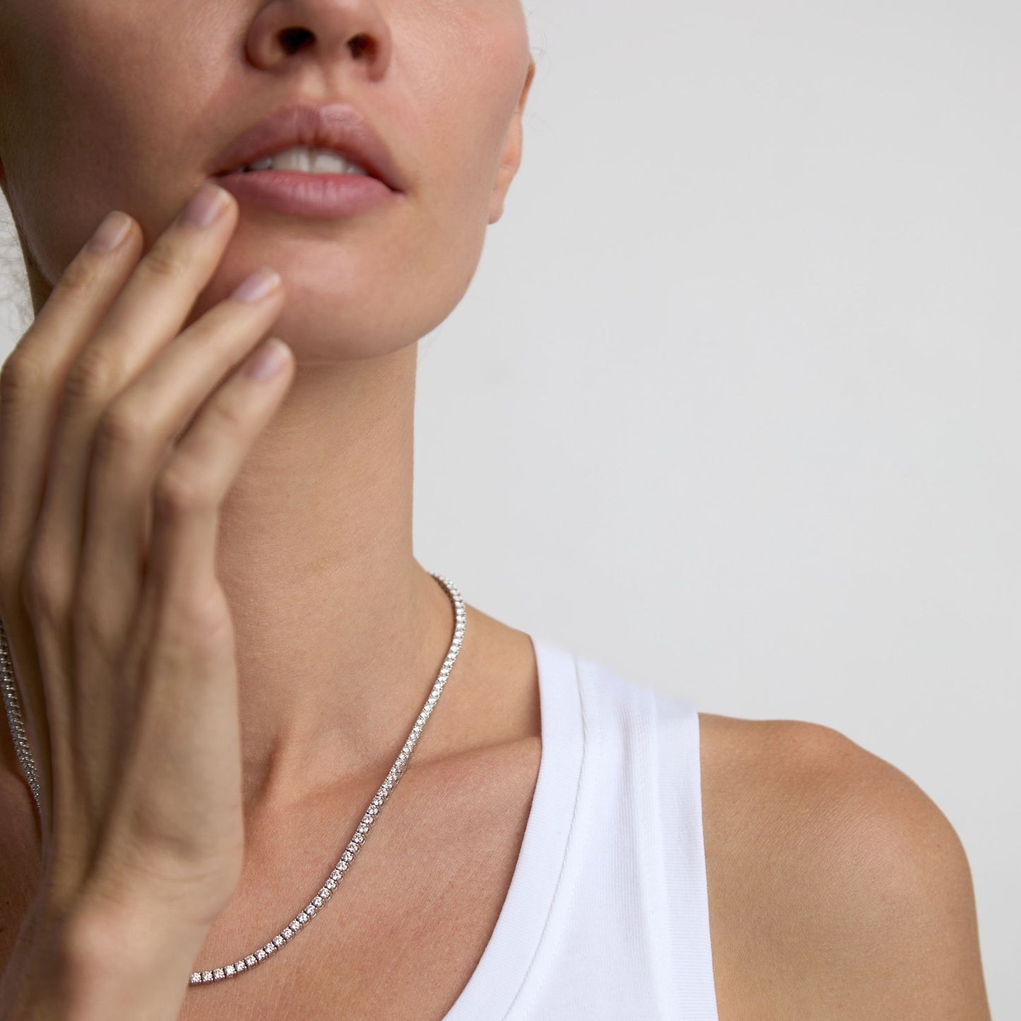 Minimal lab grown diamond tennis necklace layered against the skin