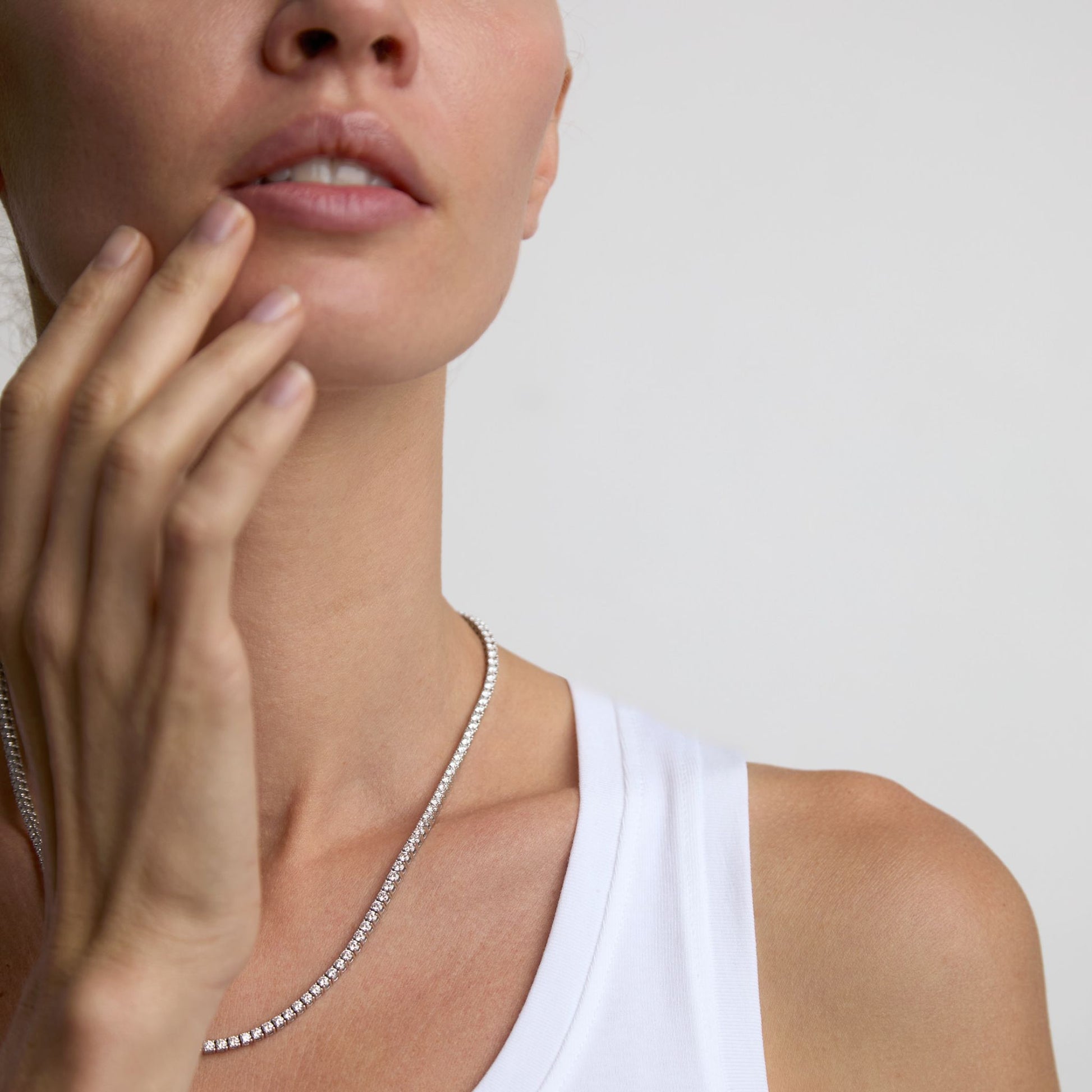 Minimal lab grown diamond tennis necklace layered against the skin