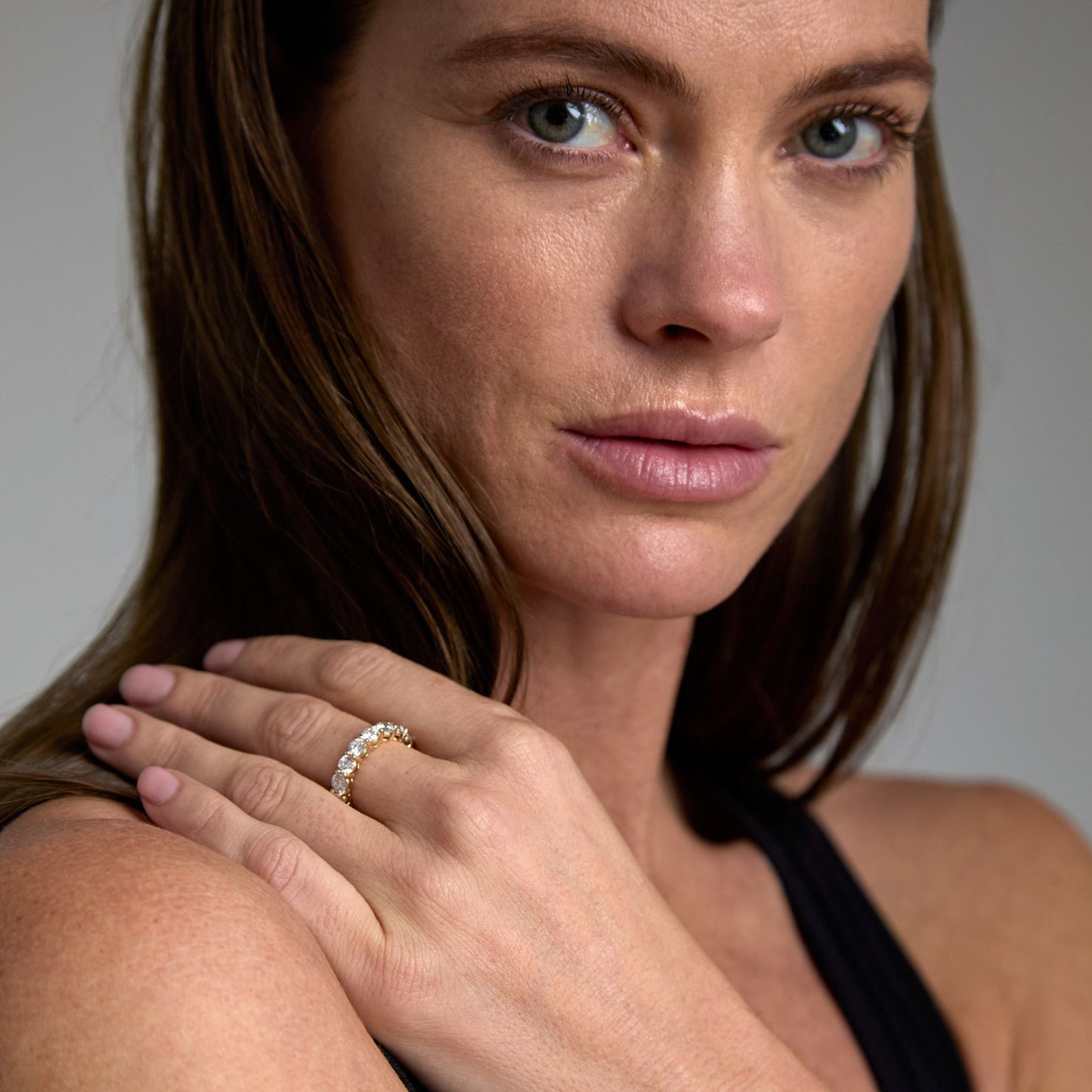 Model wearing round lab grown diamond eternity ring in 9ct yellow gold