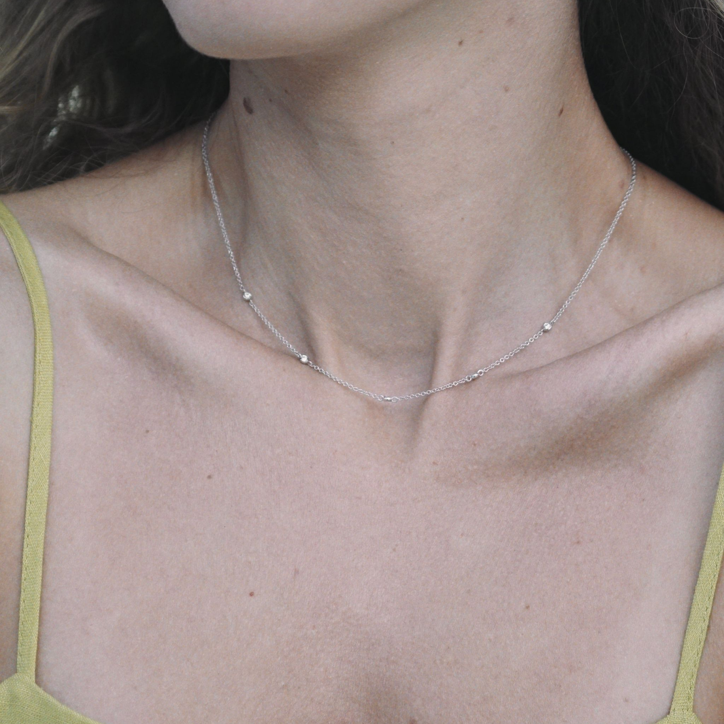 Woman wearing a natural diamond station necklace in 9ct white gold