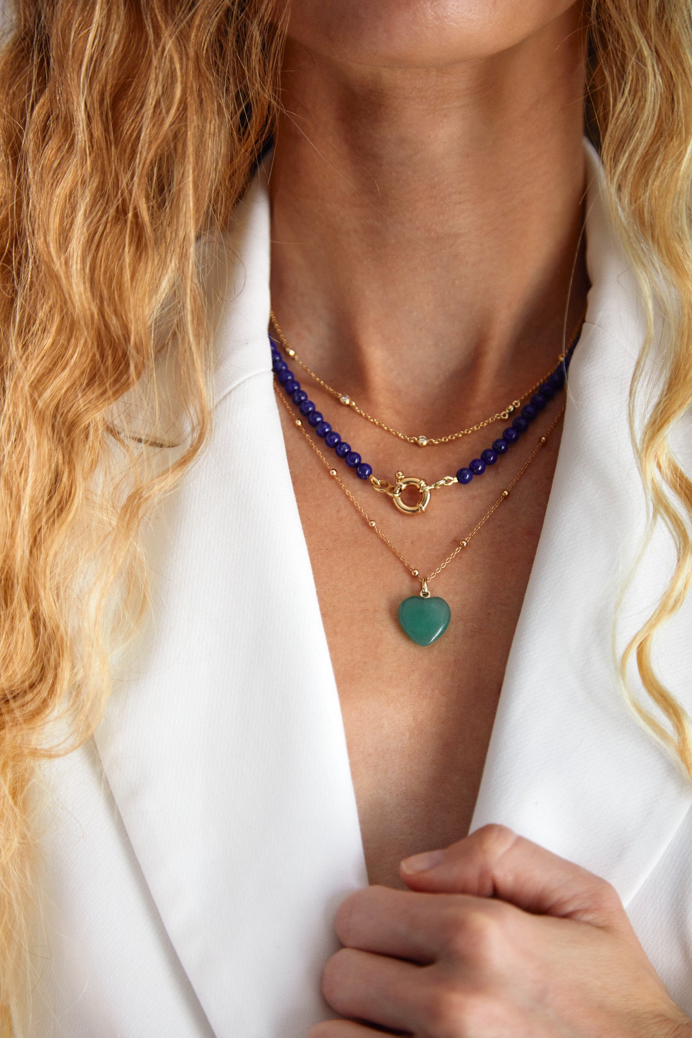 Model layering the lapis lazuli gemstone necklace with gold pendants and chains — bold summer styling by Thor Collective.