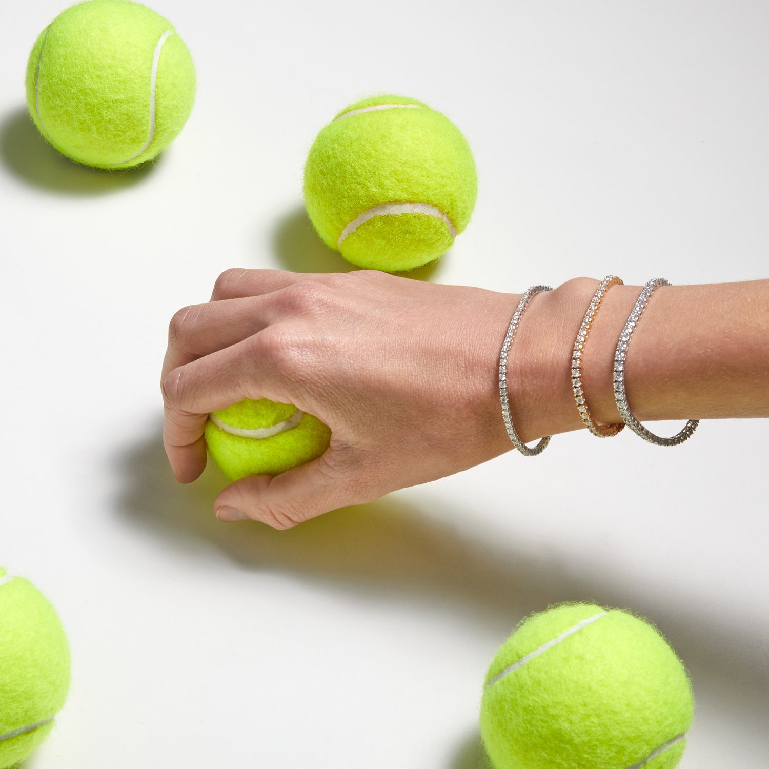 Woman wearing 9ct diamond tennis bracelets holding tennis ball — Thor Collective Modern Heirloom jewellery South Africa.