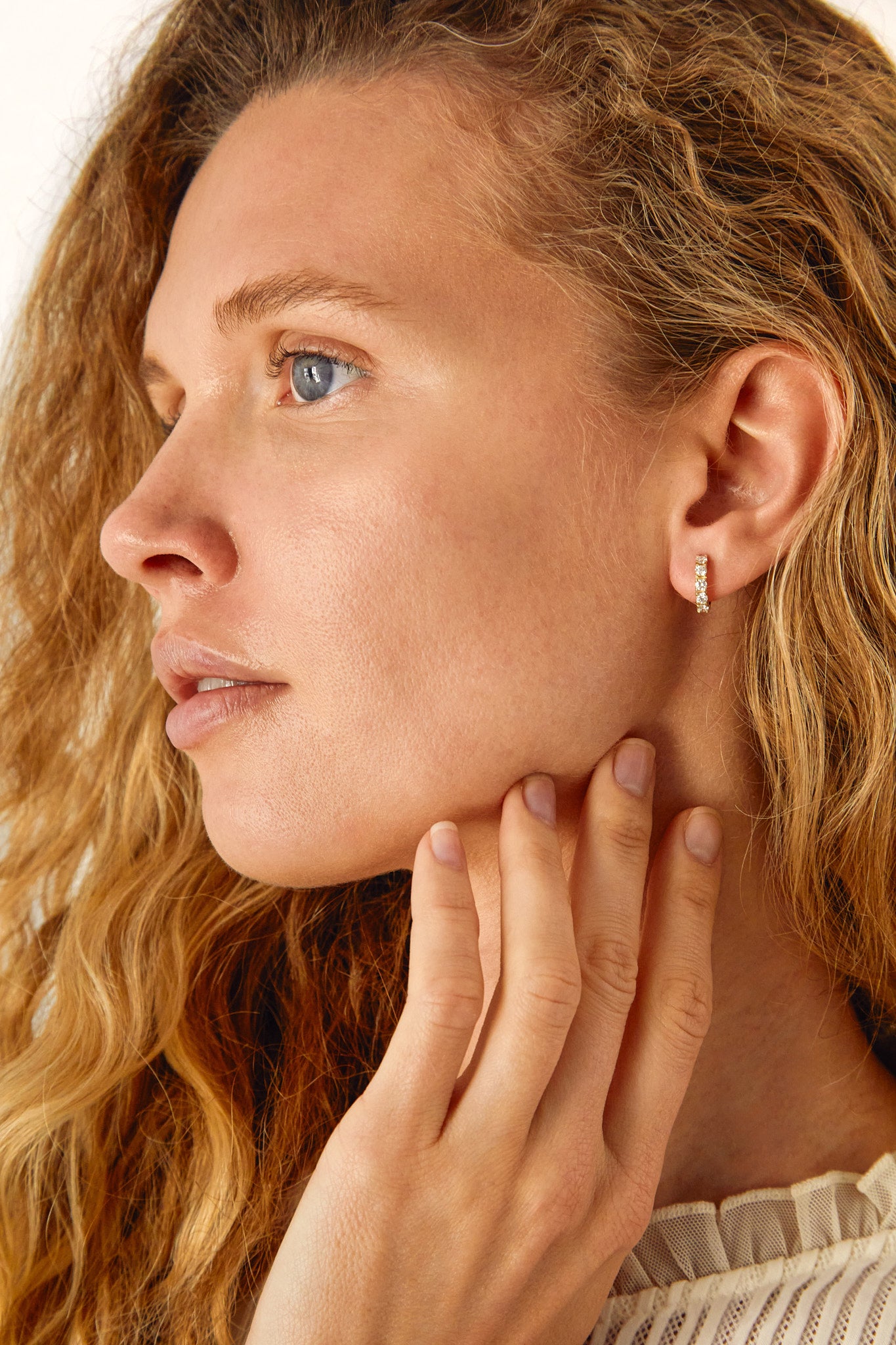 Side profile of model wearing 9ct gold lab-grown diamond huggies, showing subtle sparkle and everyday wearability.