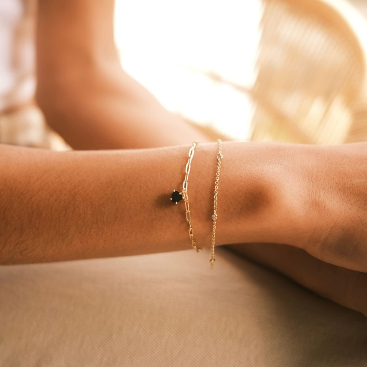9ct gold heart bracelet with black spinel gemstone worn on the wrist