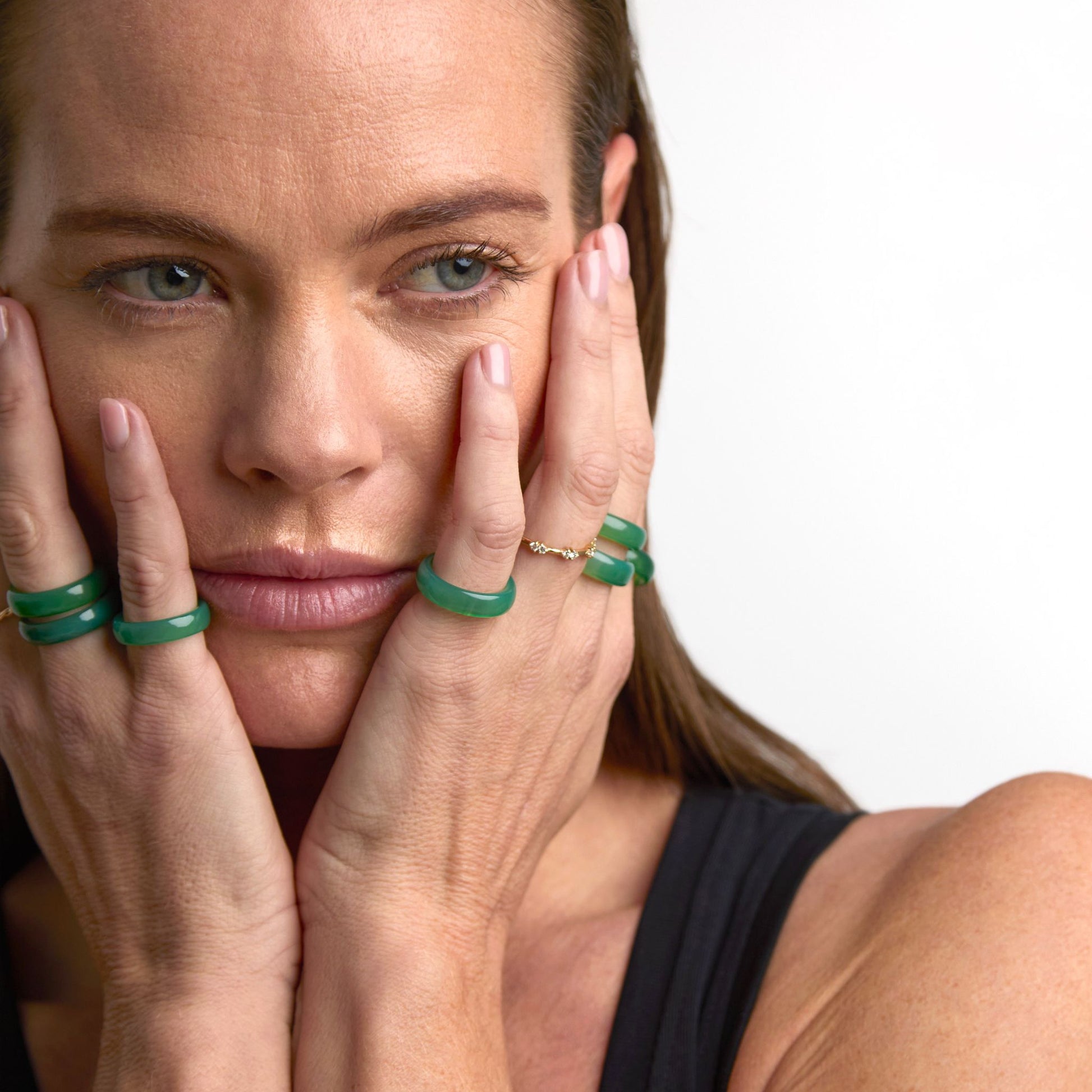 Green agate rings stacked and mixed with gold rings on hand