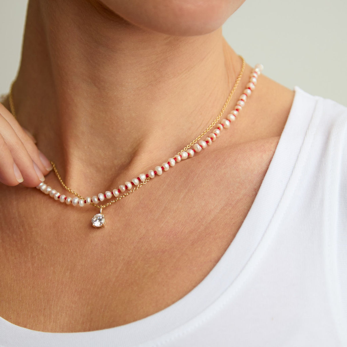 Freshwater pearl Red Thread necklace layered with a fine pendant necklace